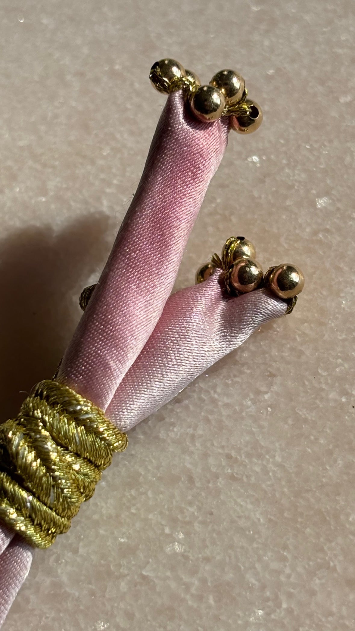 Pink silk bracelet closeup with gold beads by Boussidan.