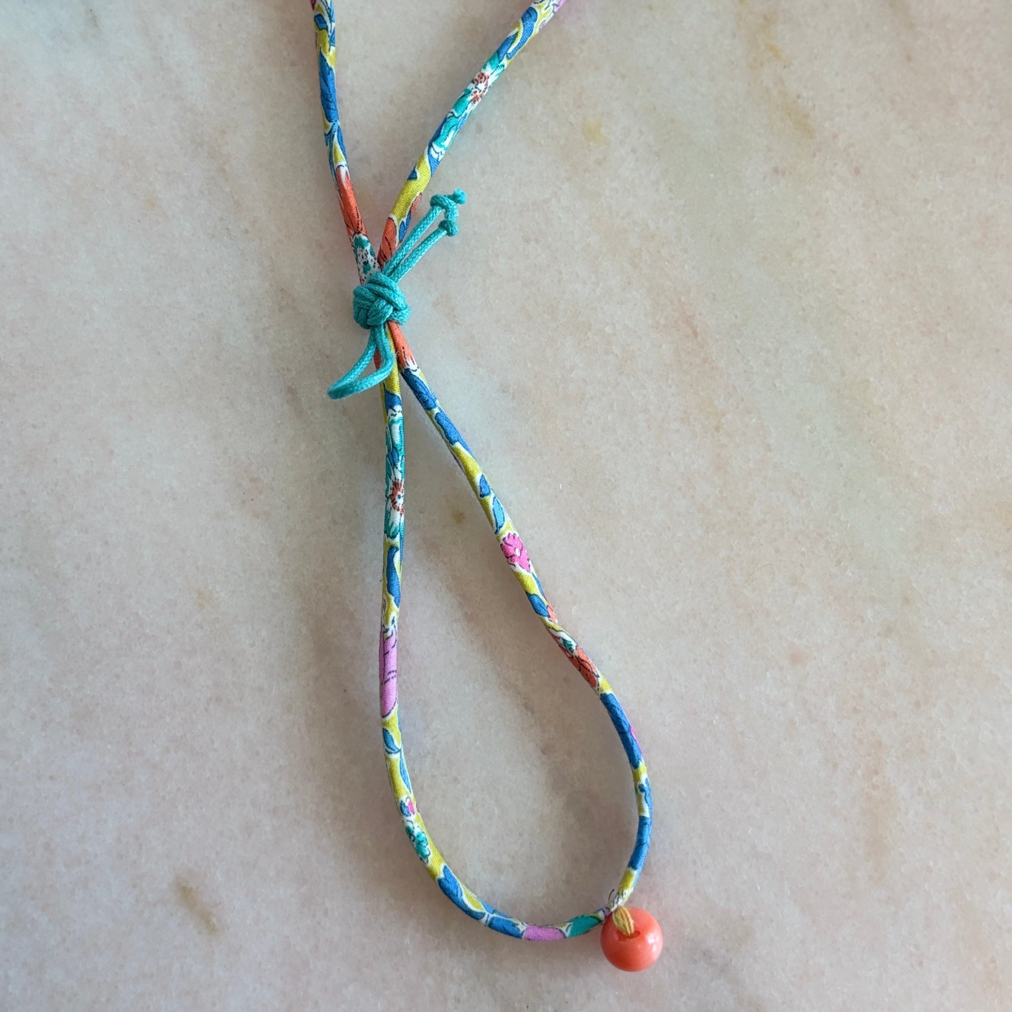 Side view of Wild-Flowers Liberty Bracelet showing floral cord and green sliding button by Boussidan.