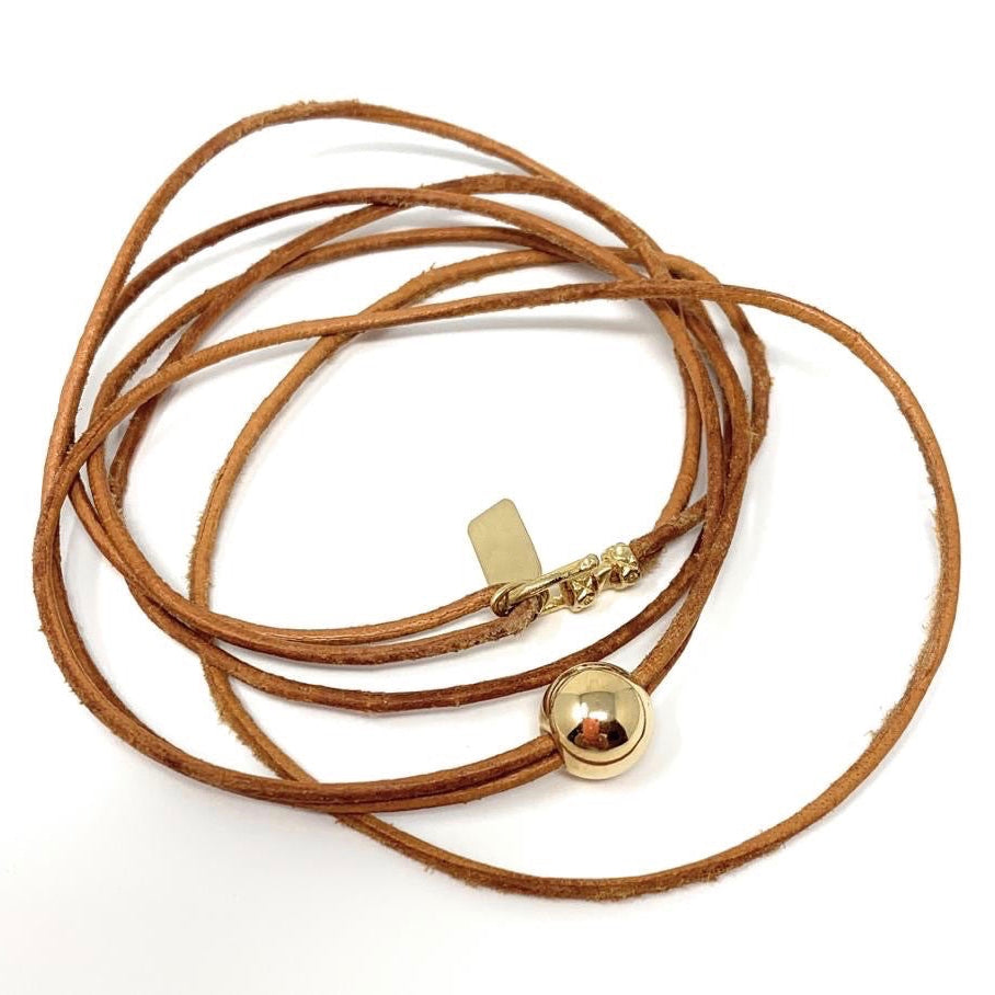 Close-up of 14k yellow gold ball on The Edge double wrap leather bracelet