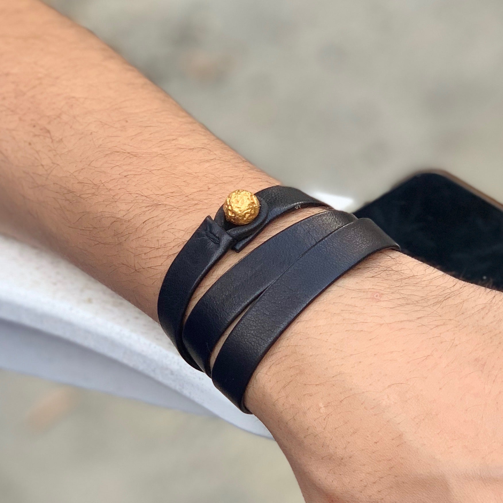 The Oro triple wrap leather bracelet on wrist, showcasing unisex luxury