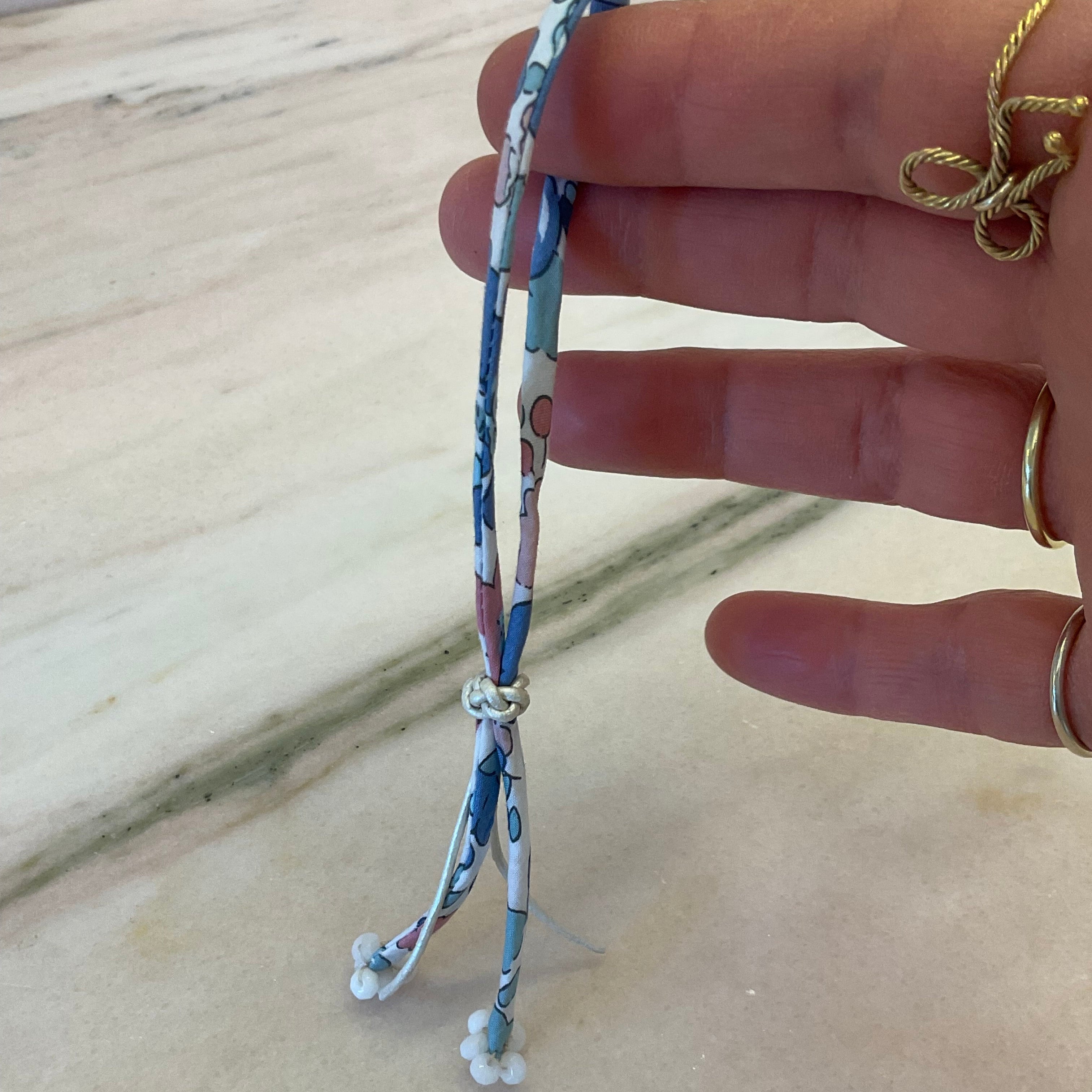 A vibrant Liberty of London floral cord finished with White Agate beads. Slide the shimmery white leather cord button up and down to adjust to your wrist by boussidan
