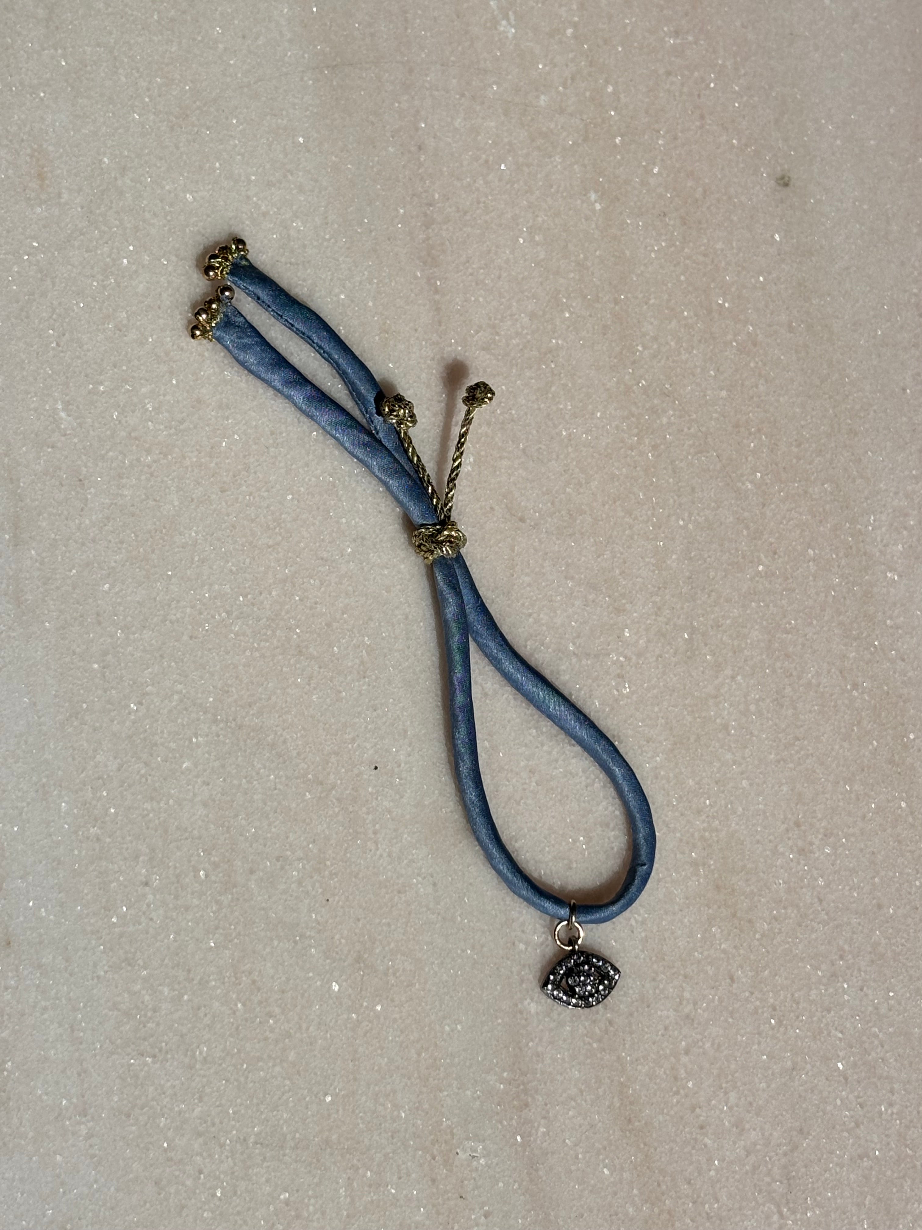 Blue Eyed Silk Kiss Bracelet with blue jeans-colored silk cord and crystal flowered eye charm by Boussidan