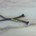 Load image into Gallery viewer, Close-up of black pearl ombre silk bracelet with adjustable gold button on silver silk
