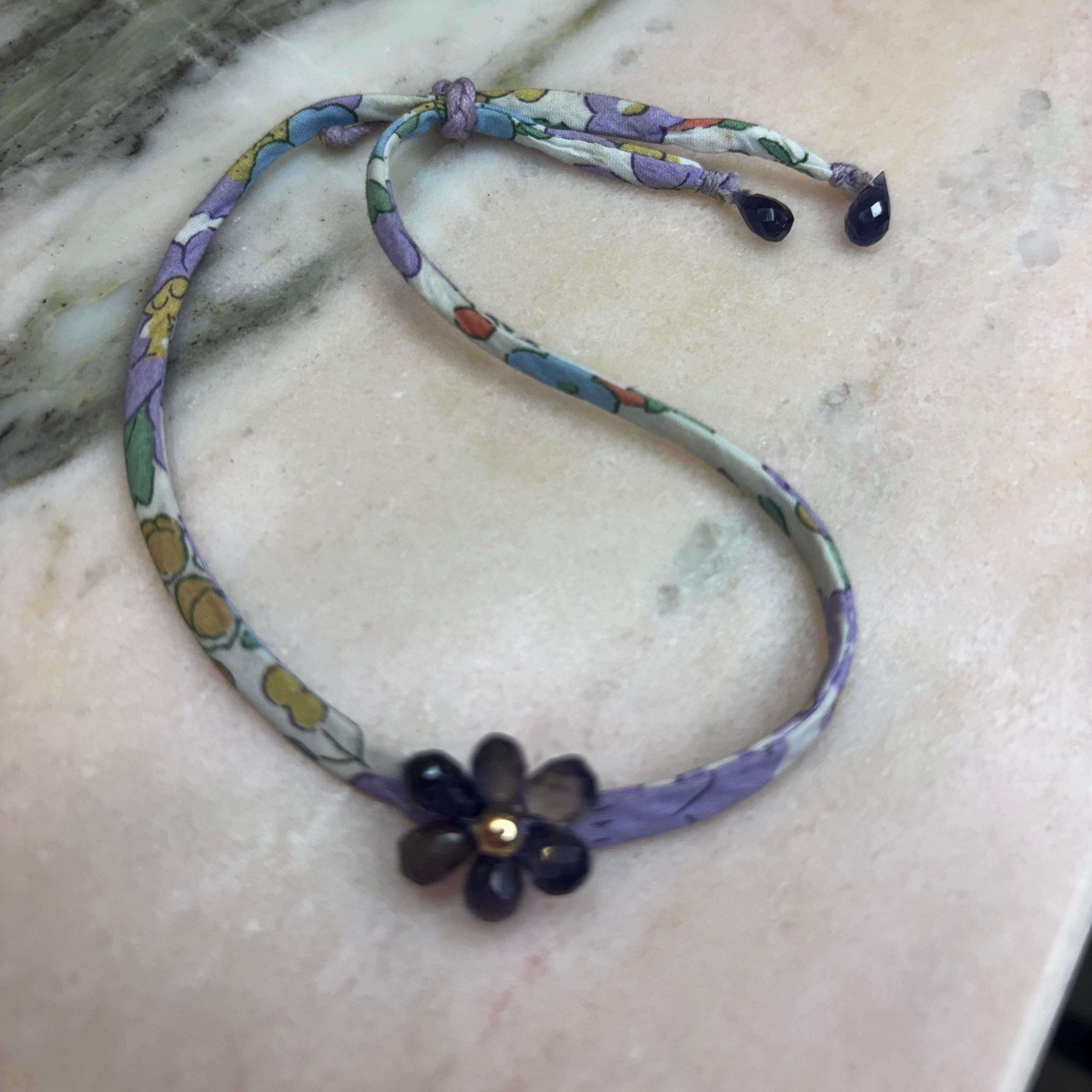 Floral patterned fabric cord  handmade amethyst flower gold filled center amethyst drops and a lavender sliding button adjustable to your wrist