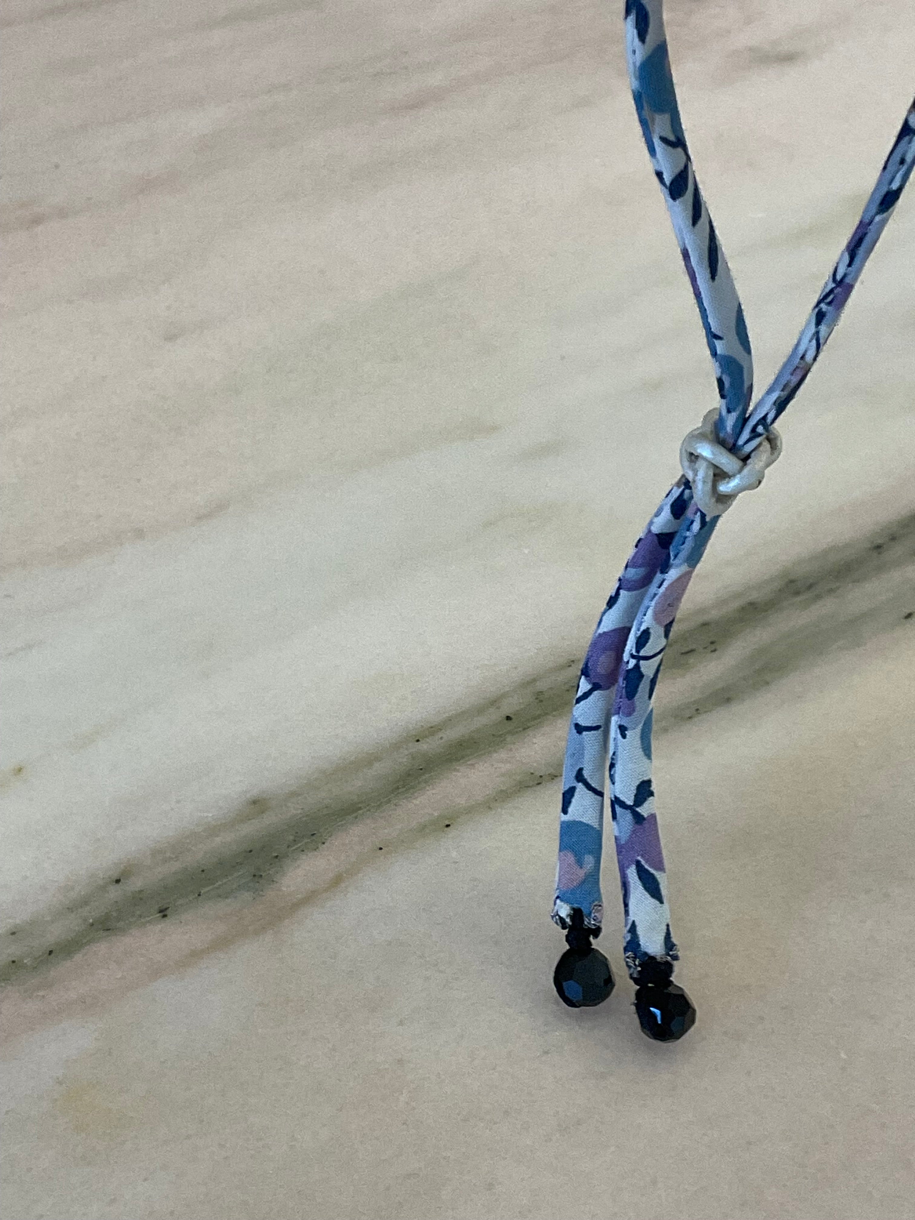 Close-up of Onyx Drops Wild-Flowers Liberty Bracelet detailing black onyx drops and leather button by Boussidan.