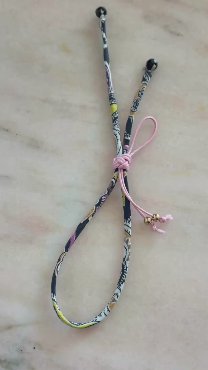 Video of Pink Paisley Wild-Flowers Liberty Bracelet showing black and pink floral cord, black spinel beads, and adjustable pink button by Boussidan.