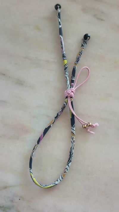 Video of Pink Paisley Wild-Flowers Liberty Bracelet showing black and pink floral cord, black spinel beads, and adjustable pink button by Boussidan.