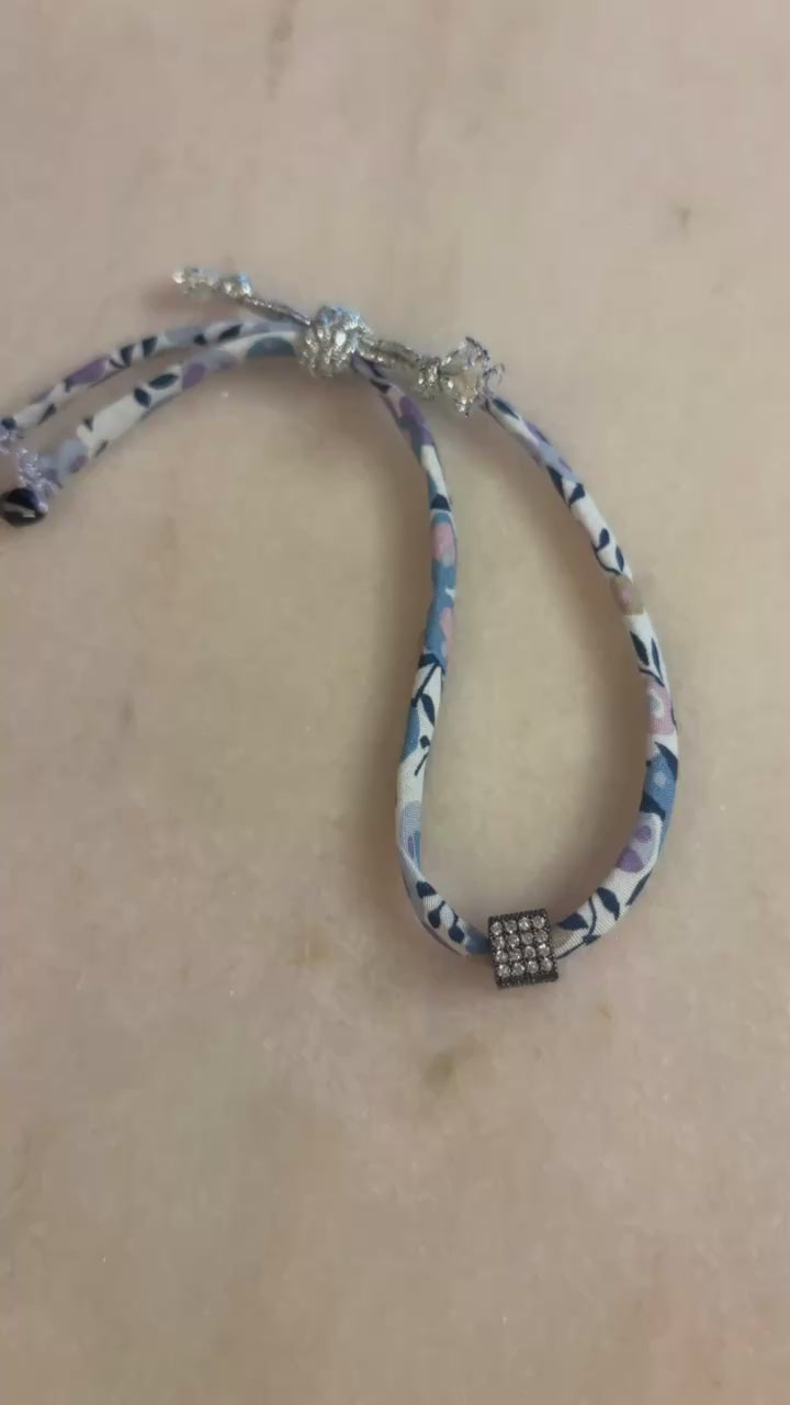 Video of Black Silver Wild-Flowers Liberty Bracelet showing the vibrant floral cord, diamond-like cube, onyx beads, and adjustable silver cord button by boussidan