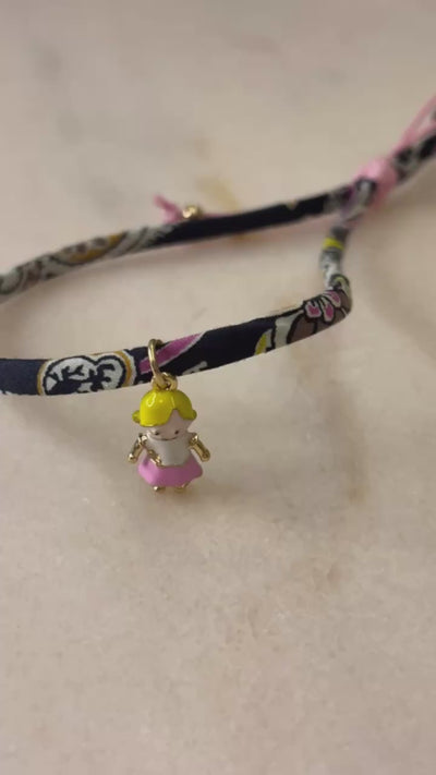 Video of Happy Girl Wild-Flowers Liberty Bracelet showing floral cord, 3D enamel charm, and adjustable pink button by Boussidan.