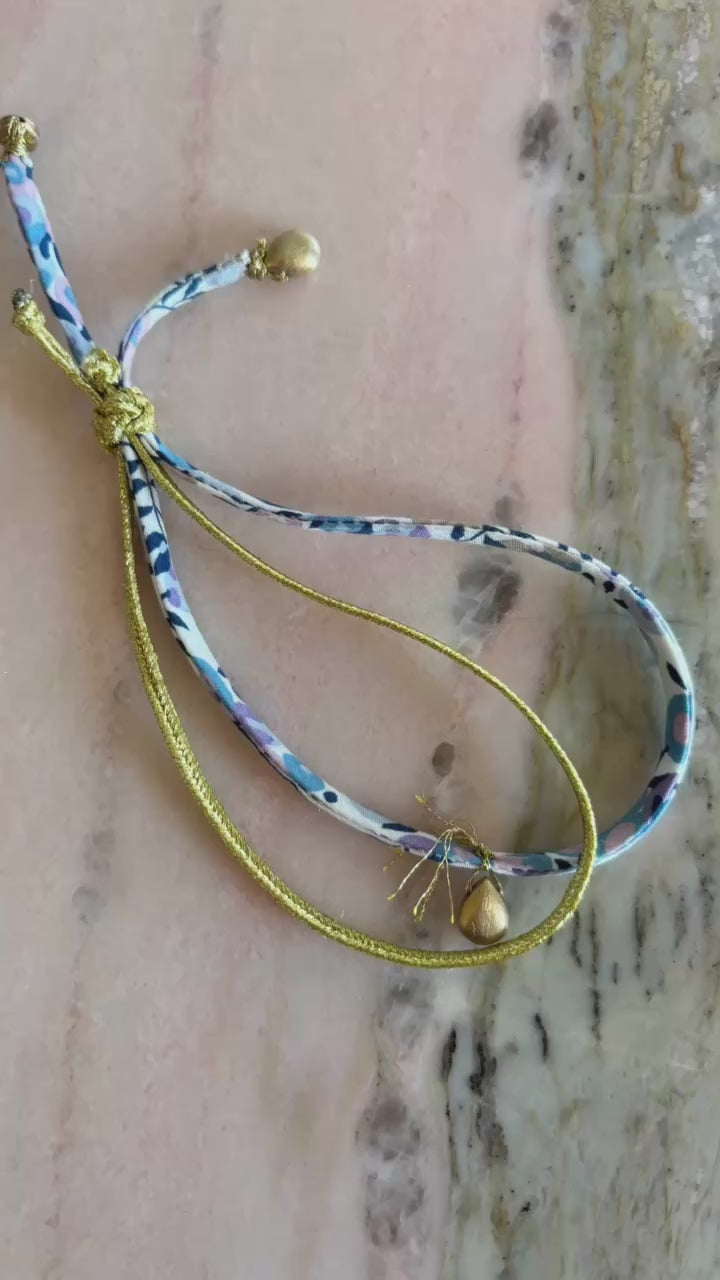 Video of Golden Drops Wild-Flowers Liberty Bracelet showing floral gold cord, gold-filled beads, and adjustable gold button by Boussidan