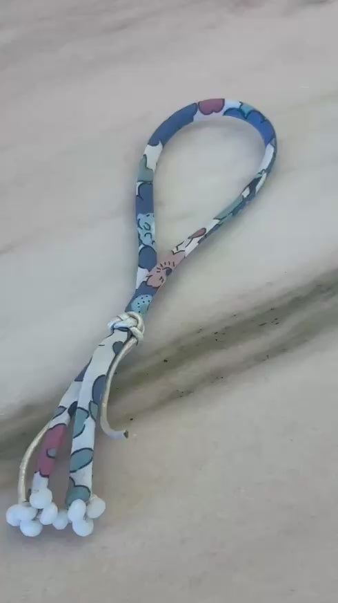 Video of Fearie Wild-Flowers Liberty Bracelet showing floral cord, white agate beads, and adjustable leather button by Boussidan.