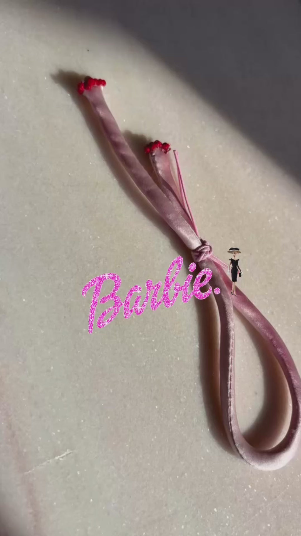 Pink silk adjustable bracelet finished with red spinel and mother of pearl clover and gold cord button slides up and down 