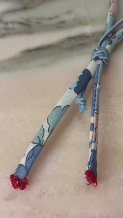 Video of Pearly White Wild-Flowers Liberty Bracelet showing floral cord, pearl drop charm, and adjustable blue button by Boussidan